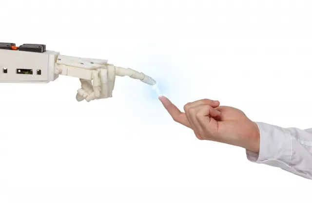 人間とロボットの手がタッチ